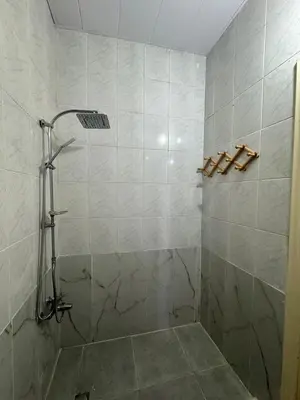 a bathroom with a shower with a tiled wall at Decapolis 8 in Irbid