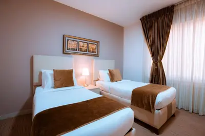 a hotel room with two beds and a window at Rawa Luxury Hotel Suites in Amman