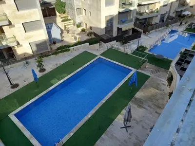 an overhead view of a large swimming pool in an apartment at Luxury home Abdoun complex in Amman