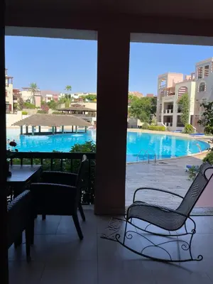 a balcony with a view of a swimming pool at Talabay two bedroom umniah pool in Aqaba