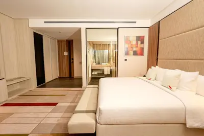 a bedroom with a large white bed and a mirror at Swisstouches Hotel Amman in Amman