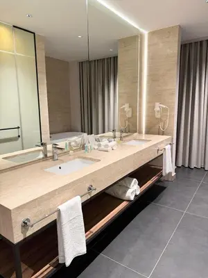 a bathroom with two sinks and a large mirror at Swisstouches Hotel Amman in Amman