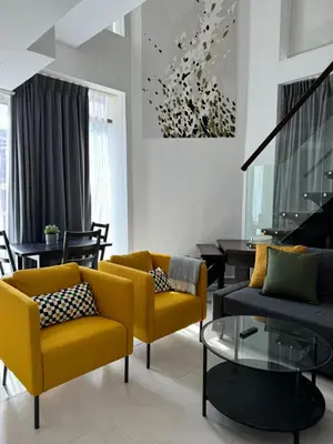 a living room with a yellow couch and a table at DAMAC Pool View Penthouse in Amman