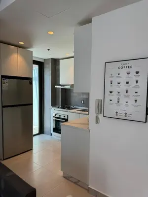 a kitchen with a stainless steel refrigerator and a stove at DAMAC Pool View Penthouse in Amman