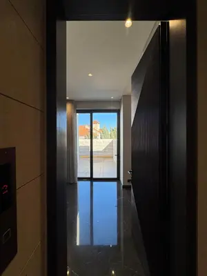 a hallway with a door leading into a house at Dabouq Luxurious Penthouse in Amman