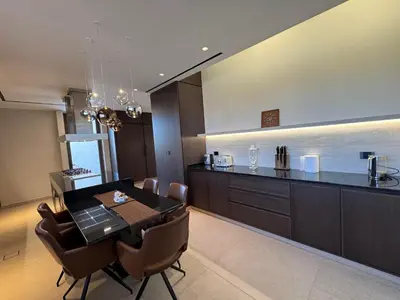 a dining room and kitchen with a table and chairs at Dabouq Luxurious Penthouse in Amman
