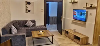 a living room with a couch and a tv at unique 2bedroom at abdoun 001 in Amman