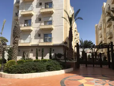 a building with palm trees in front of it at Montana Residence in Amman