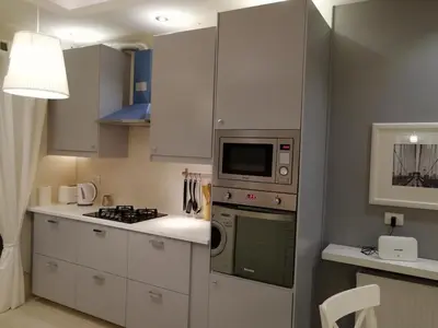 a kitchen with white cabinets and a stove and a microwave at Montana Residence in Amman