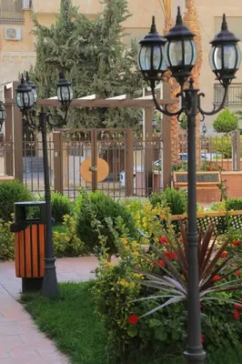 a group of street lights in a park with flowers at Montana Residence in Amman
