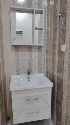 a bathroom with a white sink and a mirror at Al Wesam Furnished Apartments in Aqaba