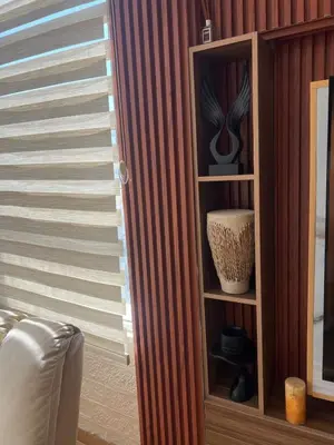 a book shelf with vases on it next to a window at Art loft in Amman
