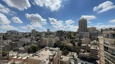 a view of a city with buildings and clouds at Art loft in Amman