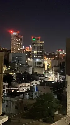 a view of a city at night with buildings at Art loft in Amman