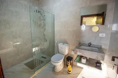 a bathroom with a shower and a toilet and a sink at Mountain Echo Inn in Taiyiba