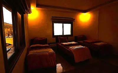 a small room with two beds and a window at Mountain Echo Inn in Taiyiba