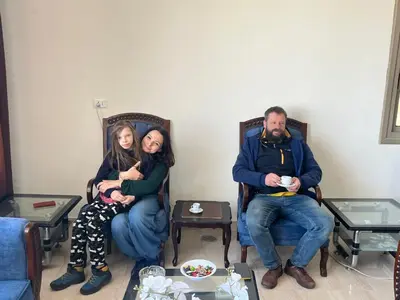 three people sitting in chairs in a room at Mountain Echo Inn in Taiyiba