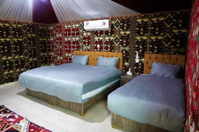 a bedroom with two beds and a wall of wine bottles at Rum Pillars Camp in Disah