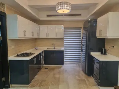 a kitchen with white cabinets and a sink and a stove at unique 2bedroom at abdoun 006 in Amman