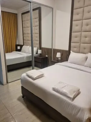a bedroom with two beds and a large mirror at unique 2bedroom at abdoun 006 in Amman