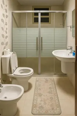 a bathroom with a toilet and a sink and a shower at Misk Home in Amman