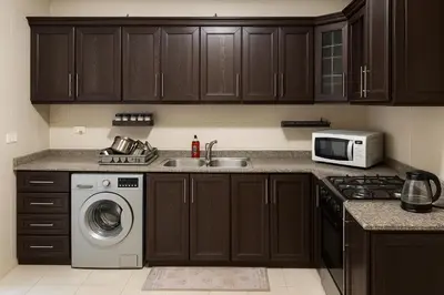 a kitchen with a sink and a washing machine at Misk Home in Amman