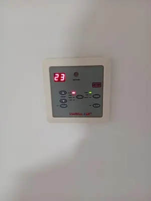 an electronic clock on a white wall with the time at Misk Home in Amman