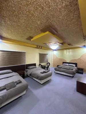 a room with four beds and a table in it at WaterMill House in Wadi Musa