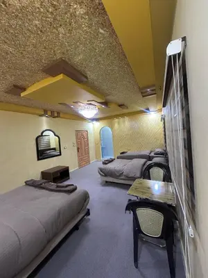 a room with two beds and a table and chairs at WaterMill House in Wadi Musa