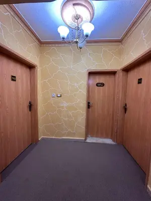 an empty room with two doors and a chandelier at WaterMill House in Wadi Musa