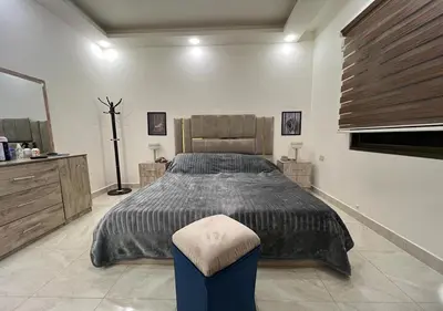 a bedroom with a bed and a stool in it at Sweet Home In Amman - Family Friendly in Amman