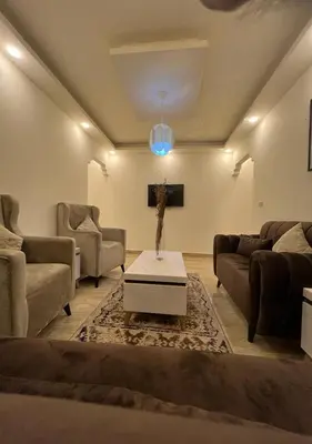 a living room with two couches and a table at Sweet Home In Amman - Family Friendly in Amman