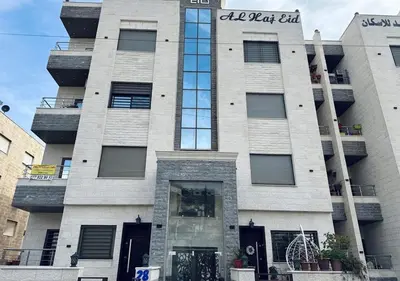 a tallartment building with a sign on the front of it at Sweet Home In Amman - Family Friendly in Amman