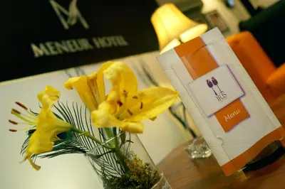 a vase filled with yellow flowers on a table at Meneur Hotel in Amman