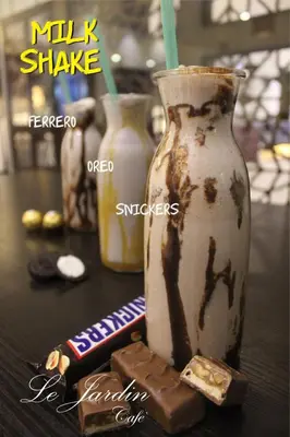 a table with a milk shake and a bottle of milkshake at Meneur Hotel in Amman