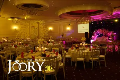 a banquet hall with white tables and chairs and lights at Meneur Hotel in Amman
