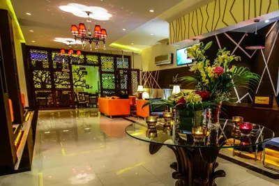 a lobby with a table with flowers on it at Meneur Hotel in Amman