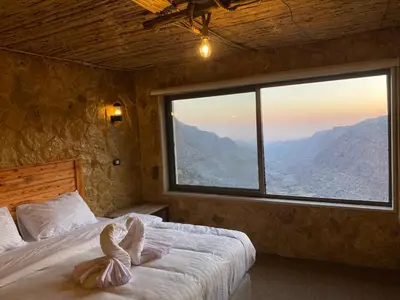 a bedroom with a bed with a large window at Dana Trail Hotel in Dana