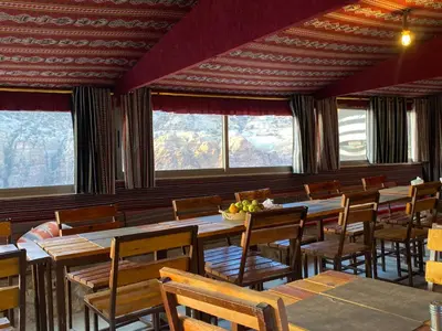 a dining room with tables and chairs and windows at Dana Trail Hotel in Dana