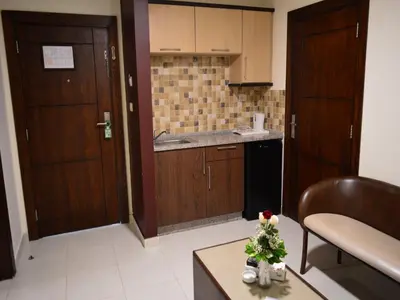 a kitchen with wooden doors and a table with flowers on it at Ream Hotel Amman in Amman