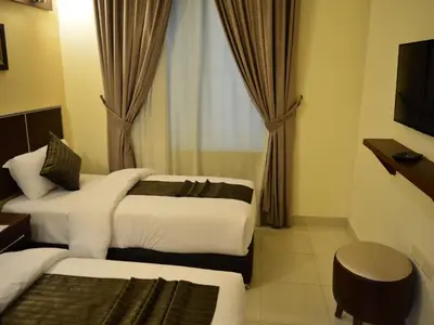 a hotel room with two beds and a window at Ream Hotel Amman in Amman