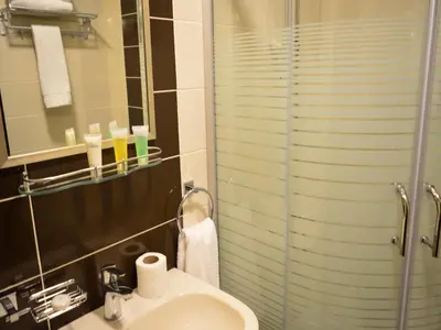 a bathroom with a sink and a glass shower at Ream Hotel Amman in Amman