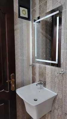 a bathroom with a white sink and a mirror at Al Wesam Furnished Apartments in Aqaba