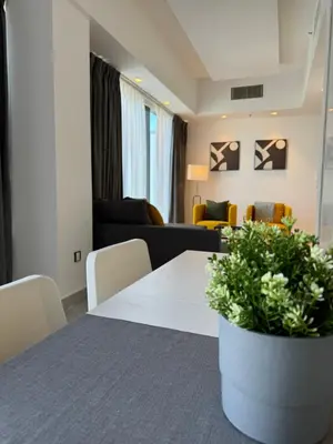 a living room with a table and a couch at DAMAC City View Penthouse in Amman
