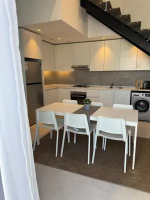 a kitchen with a table and chairs in a kitchen at DAMAC City View Penthouse in Amman