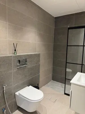 a bathroom with a toilet and a sink at DAMAC City View Penthouse in Amman