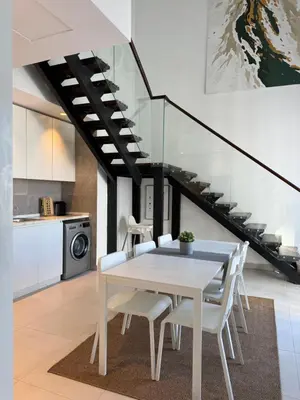 a dining room with a white table and chairs at DAMAC City View Penthouse in Amman