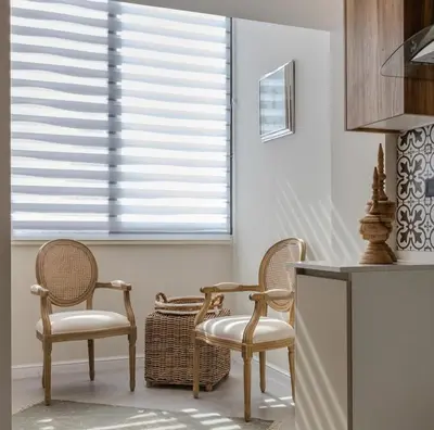 a kitchen with two chairs and a table and a window at Flamant Apartments in Amman
