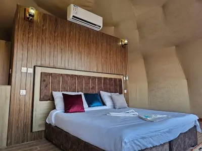 a bedroom with a large bed with a wooden wall at Laurana Rum Luxury Camp in Wadi Rum