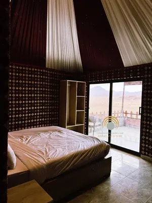 a bedroom with a bed with a view of the desert at Laurana Rum Luxury Camp in Wadi Rum